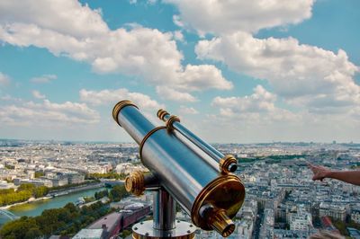 Close-up of telescope against cityscape and sky