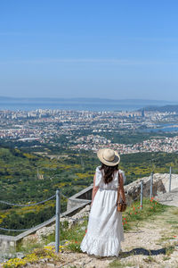 Rear view of woman standing on hill at klis fortress above city of split in croatia