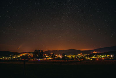 Scenic view of landscape against sky with the comet neowise