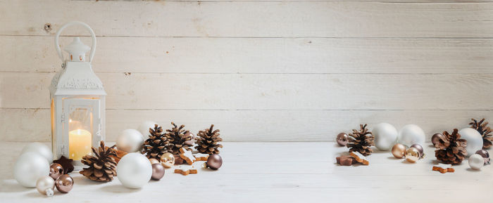 Close-up of lit candle amidst christmas decoration on table