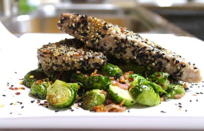 Close-up of tuna fish garnished with sesame seeds in plate