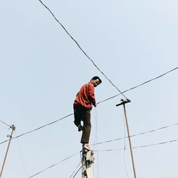 Low angle view of man against clear sky