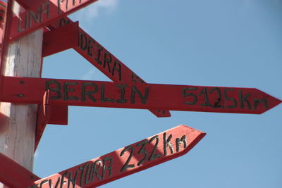 Low angle view of direction signs against clear sky