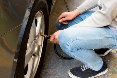 A man unflating tire of car