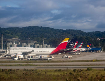 Airplane on airport runway against sky