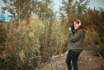 Full length of man photographing in forest