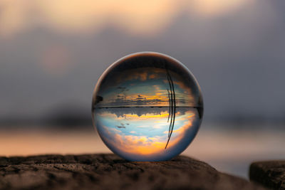 Close-up of crystal ball on rock at sunset