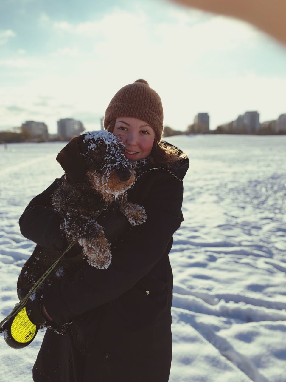 winter, one person, clothing, warm clothing, looking at camera, real people, water, three quarter length, portrait, cold temperature, standing, nature, animal themes, day, smiling, snow, animal, leisure activity, pet owner, outdoors