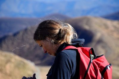 Close-up of woman standing against hills