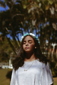 Close-up of young woman against trees