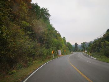 Road amidst trees against sky