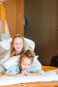 Portrait of smiling girl lying on bed