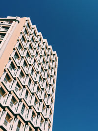 Low angle view of modern building against clear blue sky