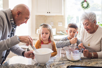 Multigenerational family cooking pancakes for breakfast