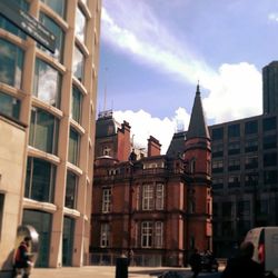 Buildings in city against cloudy sky