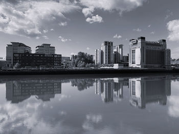 Reflection of buildings in lake against sky