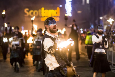 People standing on city street at night