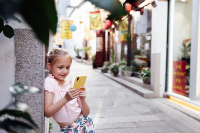 Portrait of smiling young woman using mobile phone