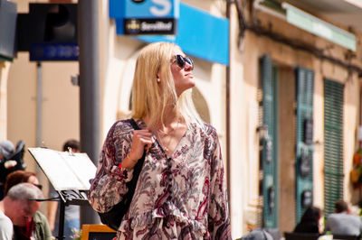 Young woman wearing sunglasses in city