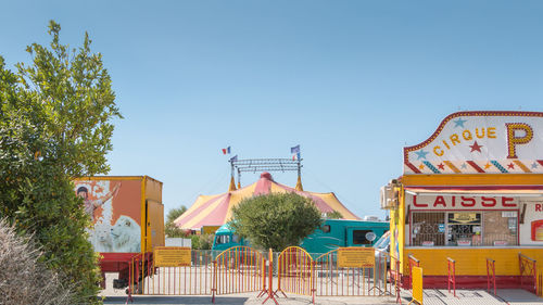 View of amusement park against clear blue sky