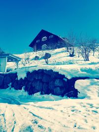 Snow covered landscape against clear blue sky