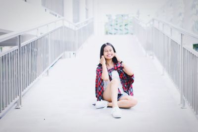 Portrait of young woman against railing