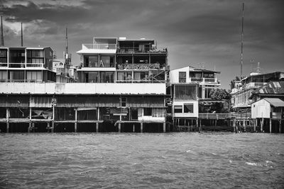 Buildings by sea against sky