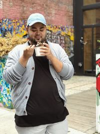 Full length of young man standing against drink