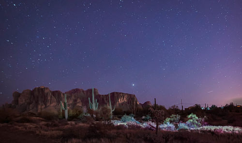 Scenic view of landscape against star field at night