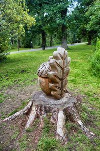 Sculpture on field against trees