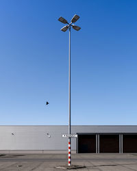 Low angle view of street lights against clear blue sky