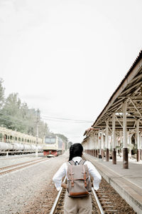Rear view of woman on railway tracks