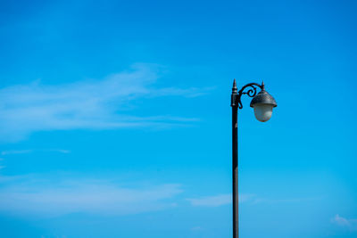 Low angle view of street light against blue sky