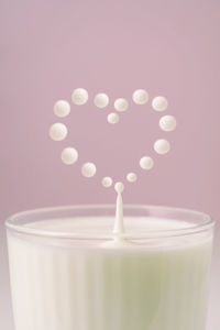 Milk drips into a transparent faceted glass.