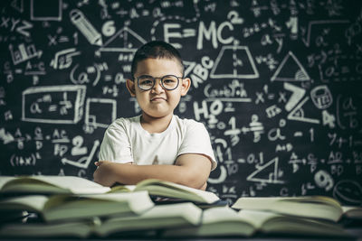 Portrait of boy with book in background