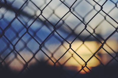 Close-up of water drops on chainlink fence