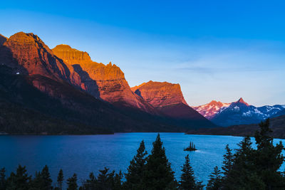 Scenic view of lake by mountains against sky