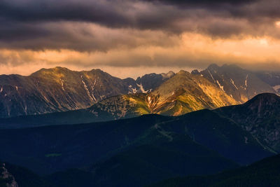 Scenic view of snowcapped mountains against sky at sunset