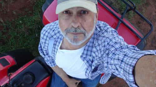 Portrait of mature man on quadbike at field