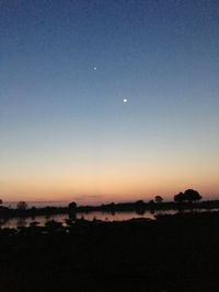 Scenic view of silhouette land against clear sky at sunset