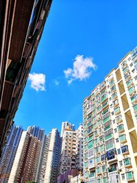 Low angle view of modern buildings against blue sky