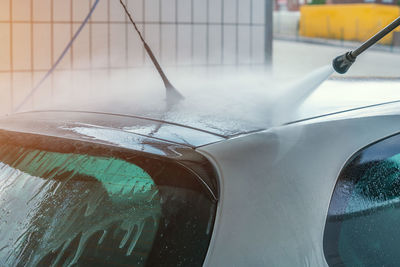 Hose spraying water on car roof