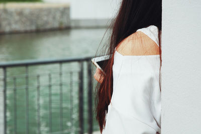 Portrait of woman standing against white wall