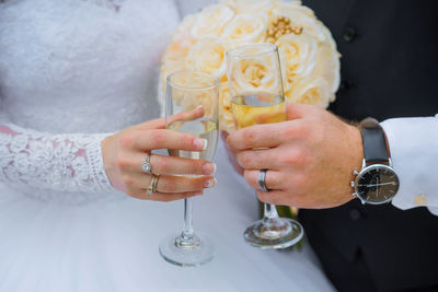 Close-up of couple clinking champagne glasses on wedding