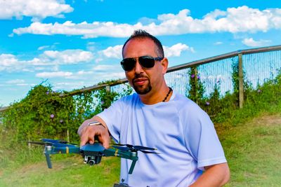 Portrait of young man wearing sunglasses against sky