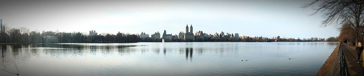Panoramic view of lake by city against sky