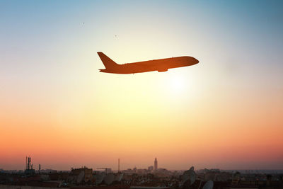 Silhouette of airplane flying in sky