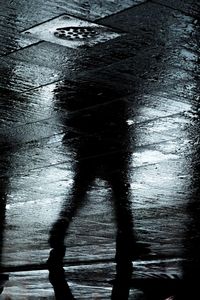 High angle view of silhouette man walking on wet road