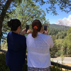 Rear view of woman photographing against sky