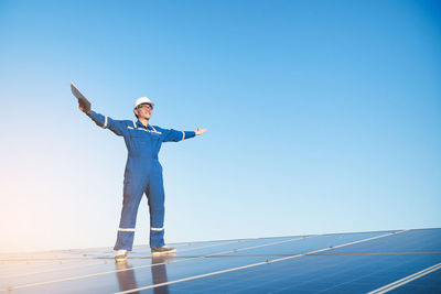 Full length of man standing against clear blue sky